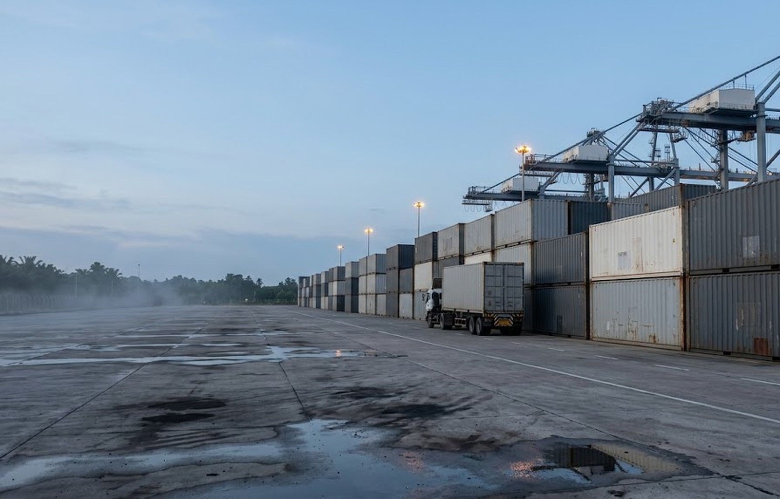 Rows of stacked containers in a terminal yard at first light.